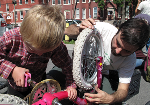 Nicholas Turner, 4, gets help fixing his sister's bike from volunteer Frank Cetera at the St. Lucy's Roman Catholic Church hub.